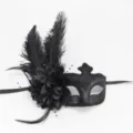 Gros plan de détail d'un masque de bal masqué noir avec plumes, fleurs et rubans élégants. - Noir