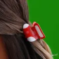 Nahaufnahme einer roten Weihnachtssocken-Haarklammer mit weißen Schneeflocken-Motiven. - H440 Weihnachtsstrumpf-Stil