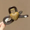 Detailaufnahme der koreanischen braunen Haarklammer mit glänzendem 3D-Herzmotivelement. - L / Braun
