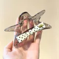 Vue détaillée d'une pince à cheveux unique en forme d'étoile avec un nœud à pois élégant. - Pince à Griffe Étoile / Pois Noir Blanc