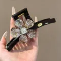 Nahaufnahme einer eleganten schwarzen Harz Haarklammer mit funkelndem Blumen- und Kristalldesign. - Goldene Metallische Rosenform / Extra Groß (ca. 15cm) / Schokoladenbraun