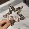 Dettaglio ravvicinato della molletta per capelli a stella in acetato con fiocco rosa lucido. - 2# Fiocco Piccolo Pinza Stella
