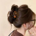 Nahaufnahme einer eleganten Schildpatt Herz Haarklammer im Dutt, ideal für schicke Alltagsdetails. - Kleines Herz Kreuz