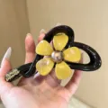Elegante Blumen-Haarklammer in Schwarz und Gelb, ideal für stilvolle Hochsteckfrisuren. - Blumen-Haarklammer / Gelb