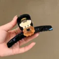 Nahaufnahme des süßen Welpen Haargreifers, schwarze Acetat Haarklammer für elegantes Styling. - Hellschwarz