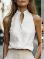 Vista dettagliata del top smanicato monocolore con scollo a V, stile minimalista. - Bianco