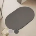 Detalle de primer plano de alfombrilla ovalada minimalista absorbente con opciones de color. - 40*60cm / Gris oscuro