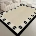 Living room rug detail showing modern geometric border design in beige and black tones. - New York Impression