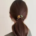 Vue détaillée du joli élastique à cheveux ours mignon avec perle verte et nœud pour queue de cheval. - Kaki