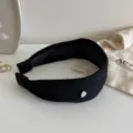 Schwarzes gestricktes breites Stirnband mit silbernem Herzakzent, minimalistisch elegant. - Schwarz