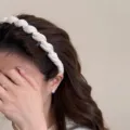 Vue détaillée d'un élégant serre-tête tressé blanc doté de dents antidérapantes pour femmes. - Beige