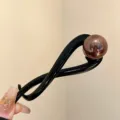 Stylish black twist hair clip featuring a glossy brown pearl bead for chic updos. - Twist Clip / Bright Black