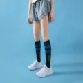 Close-up view of black compression sports socks featuring blue stripes and white letter print. - Mid-Calf Black with Blue Stripes