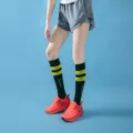 Close-up detail of women's sports compression long socks with striped pattern for fitness running. - Mid-Calf Black with Yellow Stripes