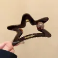 Primer plano detallado de la pinza de pelo de estrella marrón oscuro, accesorio elegante. - Pinza de Garra de Estrella y Perla / L / Marrón Chocolate