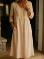 Detailed view of a casual long sleeve button down linen dress in a cozy indoor scene. - S / Apricot
