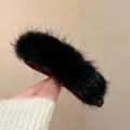 Close up of a winter black plush fur hair clip detail, showing soft fluffy texture and design. - Black