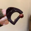 Primo piano dell'elegante molletta per capelli cava marrone scuro con dettaglio di perla. - Piccolo (6cm) / Semicerchio Perla Etichetta Oro Molla per Capelli