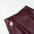Detalle de piel sintética brillante, textura charol burdeos, primer plano moda mujer. - S / Bottoms / Burdeos