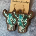 Gros plan détaillé des boucles d'oreilles en bois tête de taureau style western turquoise. - Motif Imitation Peau de Vache Turquoise (3)