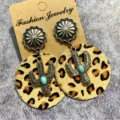 Close-up detail shot of western vintage style leather earrings with cactus pendant and leopard print. - Style 2