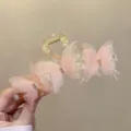 Nahaufnahme einer rosa Schmetterling-Haarklammer mit zarten Perlen und funkelnden Strasssteinen. - Rosa