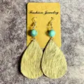 Détail en gros plan de boucles d'oreilles vintage en cuir avec perles de turquoise. - Poil de Poney Vache Noir et Blanc (4)