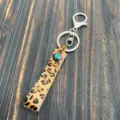 Close-up detail of the leopard print hair-on-hide keychain strap and turquoise button. - Turquoise Snap Style (5)