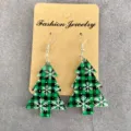 Detailed shot of Christmas tree acrylic drop earrings with green black plaid and snowflakes. - Green and Black Plaid Snowflake Christmas Tree