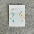 Detailed close-up view of holographic dolphin acrylic earrings on white display card. - Dolphin Style (10230146)