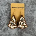 Detailed view of wooden Christmas tree earrings with leopard print hair inlay and gold hooks. - Christmas Tree Style (2) / Brown Leopard Style (2)