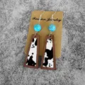 Close-up of wooden turquoise cow print drop earrings detail, featuring geometric frame design. - Black White Cowhide Geometric Style(1)