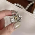 Vista dettagliata di un fermaglio per capelli in metallo a fiocco argento e oro compatto. - Molla Fiocco / Argento & Oro (C101)