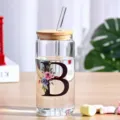 Clear glass tumbler cup with bamboo lid and glass straw, floral letter design for cold drinks. - Style B