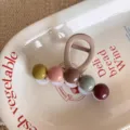 Gros plan détaillé d'une pince à cheveux perlée colorée sur un élégant plateau en céramique. - Couleur Thé au Lait