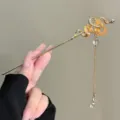 Detailed close-up of a vintage gold snake hair stick with amber crystal and hanging tassel decor. - Golden Snake With Yellow Crystal (FZ25276)