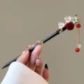 Detail of Chinese style wooden hair stick with floral decor and elegant tassel pendant. - Wenhuayu Style (FZ25114)