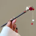 Close-up of Chinese wooden hairpin with floral charm, red rose and tassel details. - Yizainuan Style (FZ25153)