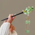 Detailed view of the handcrafted Chinese style wooden hair stick with green leaves. - Koi Green
