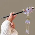 Chinese style hairpin detail showing dark brown wooden stick and purple floral tassel ornament. - Koi Purple