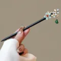 Close-up detail of traditional Chinese style wooden hairpin with floral decor and green tassel. - Weishuixiang Style (FZ25116)