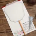 Detailed shot of traditional Chinese white silk round fan with wooden handle and silver tassel. - Beechwood Flying Immortal Pattern - Grey Border