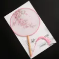 Eventail rond traditionnel chinois avec motif de fleurs de pêcher et pompon rose. - Nouveau - Vitalité du Printemps