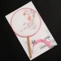 Traditional Chinese round fan with pink border, wooden handle, and tassel for dance or costume. - New - Dimly Lit Lanterns