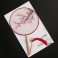 Traditional Chinese round fan with plum blossom print, wooden handle and red tassel decor. - New - Plum Blossom Painting