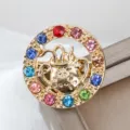 Spilla circolare dorata elegante con strass colorati e un bellissimo motivo di segno zodiacale. - Acquario (XZ25194)