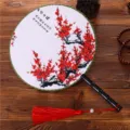 Traditional Chinese style round handheld fan featuring elegant red plum blossom and tassel. - Plums in Mountain Garden
