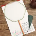Traditional Chinese round silk fan with wooden handle and green tassel for DIY painting. - Beechwood Lanterns with Green Border