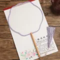 Classical Chinese style blank round silk fan featuring wooden handle and elegant purple tassel. - Beechwood Lanterns with Purple Border