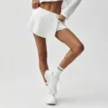 Ensemble sport blanc avec jupe-short plissée et crop top, tenue de tennis décontractée. - S / Bas / Blanc